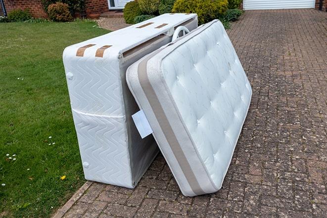 men carrying a mattress out of a house